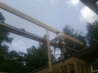 Carpenter setting a ridge beam over a new addition frame — Ice Dam Removal by Roofing Brothers in Piney Flats
