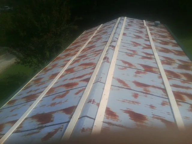 Rusted metal roof panels with new wood purlins before replacement — Storm Damage Roof Repair in Piney Flats by Roofing Brothers