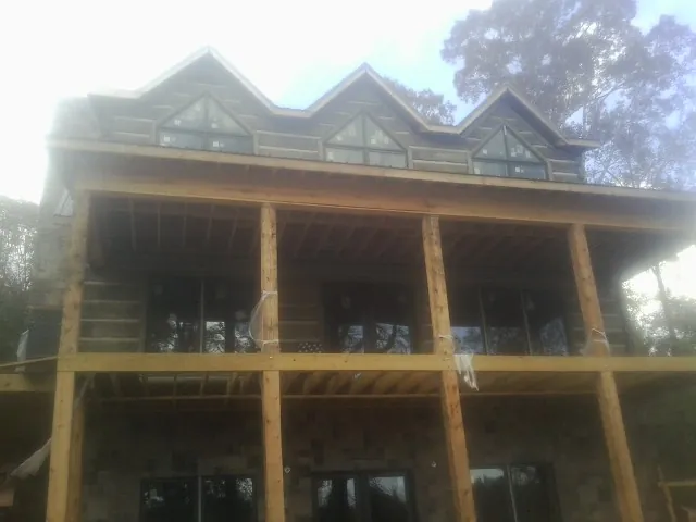 Dormers and porch framing on a large log home under construction — Roof Coating work by our crew in Piney Flats