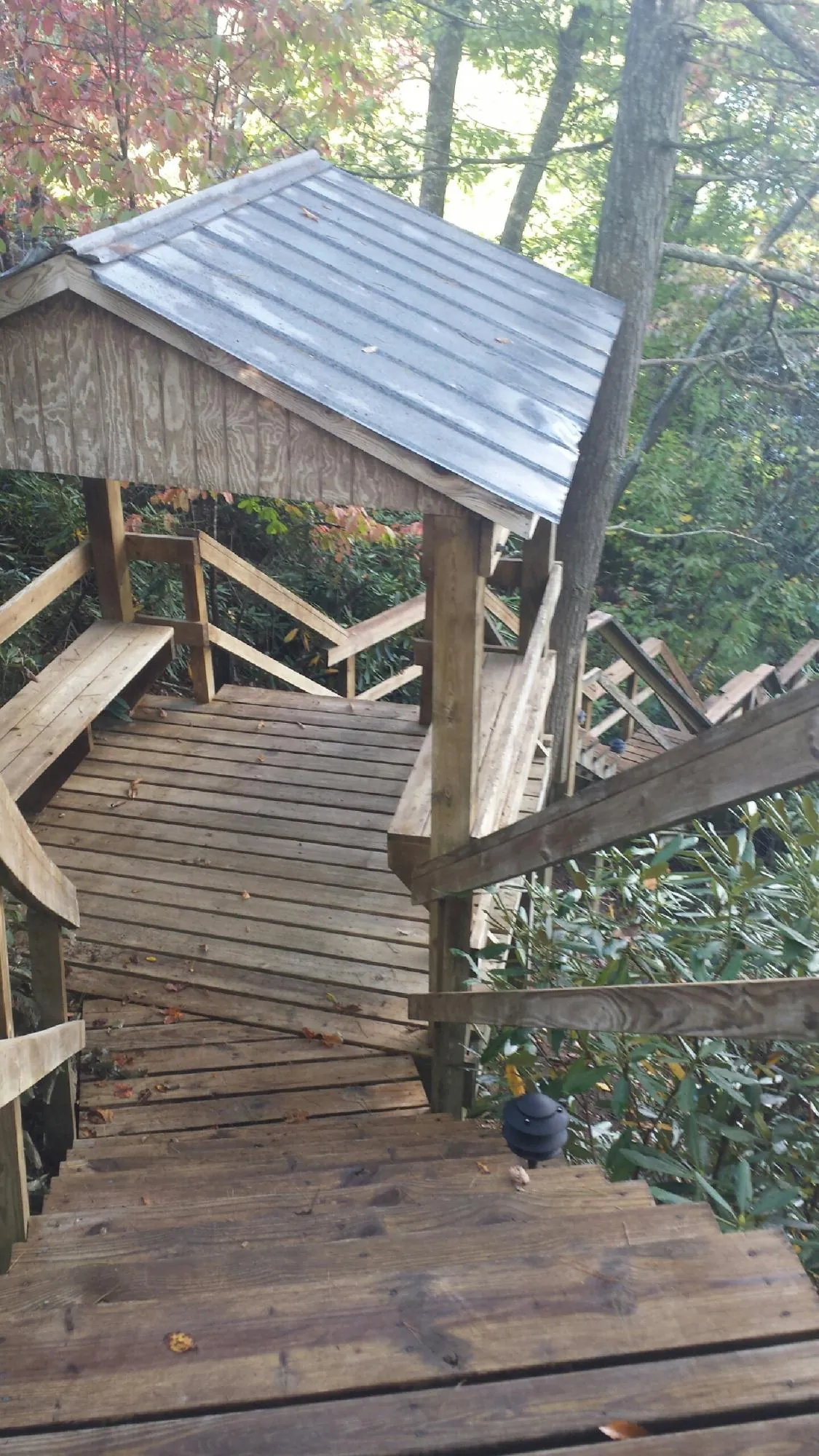 Metal roofed shelter over wooden steps on a wooded walkway — Skylight Repair & Installation work by our crew in Piney Flats