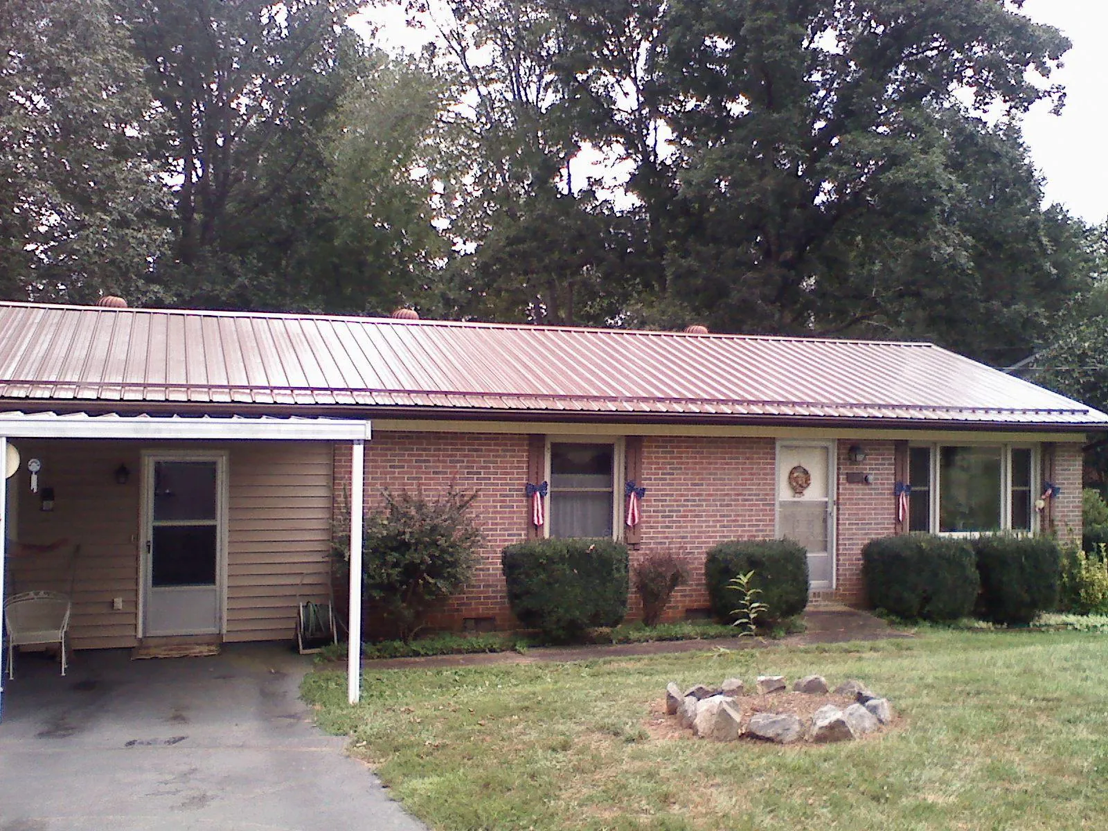 Bronze metal roof and carport on a brick ranch home — Roof Repair work by our crew in Piney Flats